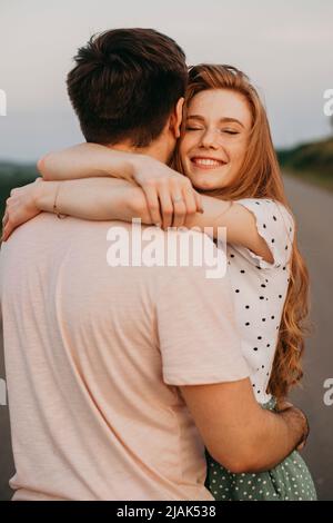 Femme remerciant son petit ami avec un câlin pour le merveilleux voyage qu'ils ont eu ensemble. Magnifique paysage d'été. Relation humaine. Amour, rencontres Banque D'Images