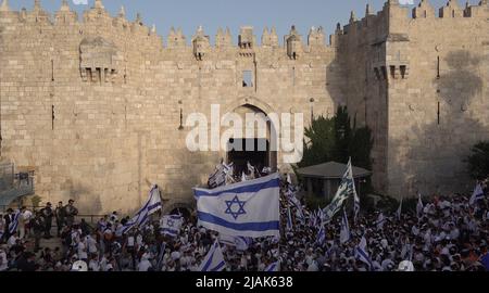 JÉRUSALEM, ISRAËL - 29 MAI : des Israéliens ultra-nationalistes scandent des slogans juifs en dansant avec des drapeaux israéliens devant la porte de Damas lors de la « Marche du drapeau » nationaliste juif pour marquer le « jour de Jérusalem » dans la vieille ville de 29 mai 2022, à Jérusalem, en Israël. La marche du drapeau de Jérusalem marque l'anniversaire de l'unification de la vieille ville et de Jérusalem-est en 1967. Banque D'Images