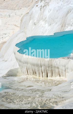 Superbes piscines bleu aqua d'eau de source riche en minéraux naturels avec de nombreuses propriétés de guérison dans la belle Pamukkale, le château de coton de l'ouest de la Turquie, une destination touristique turque majeure. Pamukkale, qui signifie ìcotton castleî en turc, est un site géologique naturel près de Denizli dans le sud-ouest de la Turquie. La région est célèbre pour ses dépôts de minéraux carbonatés laissés par l'eau thermale coulant et est l'une des destinations touristiques les plus populaires en Turquie. Banque D'Images