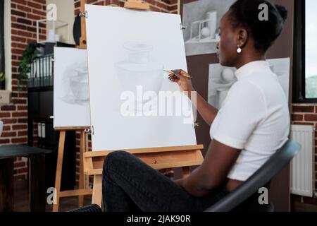 Portrait d'un jeune étudiant appréciant la classe d'art développant des compétences de peinture pour la croissance personnelle. Femme créative participant à une leçon artistique apprenant à dessiner des illustrations graphiques sur toile Banque D'Images