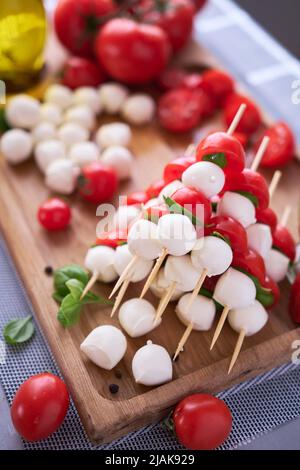 Salade Caprese - Mini fromage mozzarella dans un bol en verre, tomate et basilic Banque D'Images