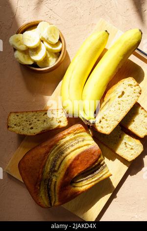 Pain à la banane. Gâteau à la banane sur planche à découper. Petit déjeuner de fond. Pose à plat. Photo verticale Banque D'Images