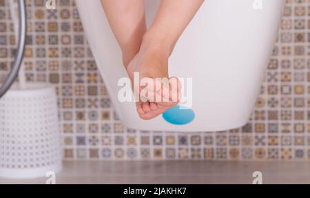 Jambes d'un enfant assis sur les toilettes dans les toilettes. Concept de formation aux toilettes et aux toilettes. Banque D'Images