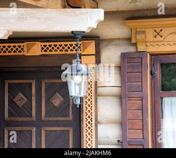 Plafond forgé pour l'éclairage sur le fond d'une maison de campagne en bois sculpté, décoration Banque D'Images