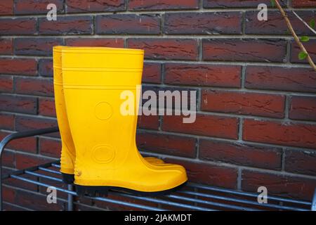 bottes en caoutchouc jaune près de l'entrée de la maison Banque D'Images