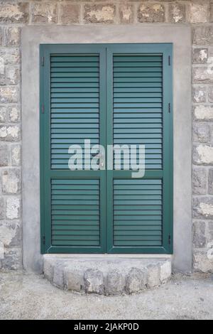 Porte verte avec volets à l'entrée de la maison Banque D'Images