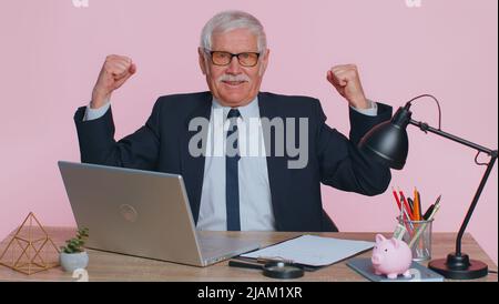 Je suis fort et indépendant. Homme d'affaires de bureau montrant le biceps, en pleine confiance, en pleine puissance de se battre pour les droits, l'énergie pour gagner le succès gagner. Homme âgé sur fond de studio rose Banque D'Images