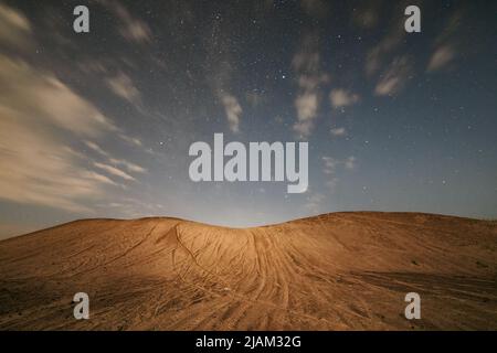 Scène nocturne avec dune de sable dans la lumière de lune et ciel étoilé. Image à exposition longue Banque D'Images