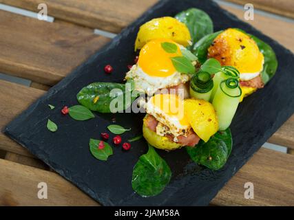 Gros plan des mini burgers des œufs de caille avec des pommes de terre cuites à l'assiette avec des légumes verts Banque D'Images