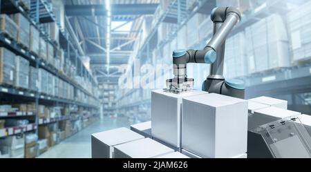 Le bras robot déplace les boîtes dans un entrepôt automatique. Concept Banque D'Images