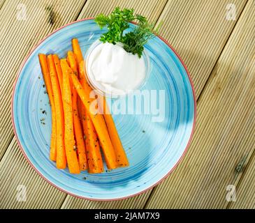 Vue de dessus des bâtonnets de carottes avec de la crème aigre Banque D'Images