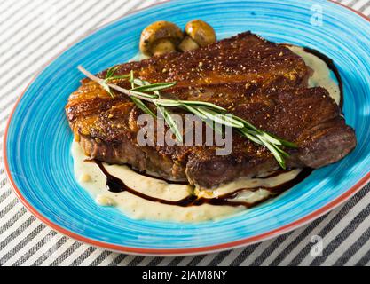 Steak de bœuf frit avec sauce aux champignons branche de romarin à l'assiette Banque D'Images