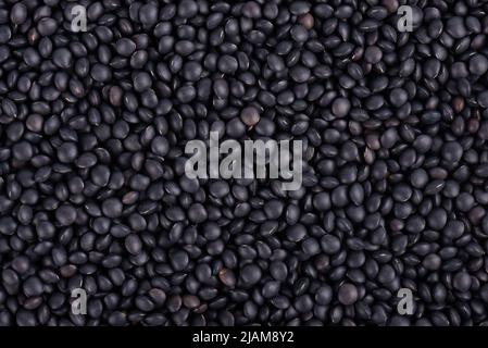 Arrière-plan lentilles noires. Grains de lentilles de béluga secs Banque D'Images