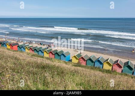 Des cabanes colorées de Whitby Beach sur le front de mer à Whitby, dans le North Yorkshire, au Royaume-Uni. Banque D'Images