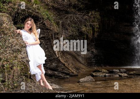 femme blonde avec robe blanche dans une rivière Banque D'Images