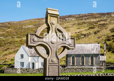 Croix celtique dans l'abbaye de St Mary avec chalet et chapelle au-dessous de Mynydd Enlli sur Ynys Enlli ou Bardsey Island, péninsule de Llyn, Gwynedd, au nord du pays de Galles, Royaume-Uni Banque D'Images