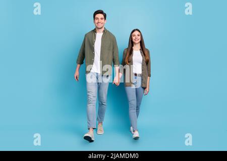 Photo pleine grandeur de charmants conjoints dame gars tenir les mains se promener temps libre isolé sur fond de ciel lumière de couleur. Banque D'Images