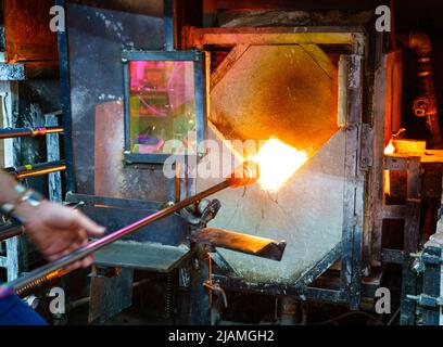 Ramollissement du verre dans un four pendant le processus de soufflage du verre Banque D'Images