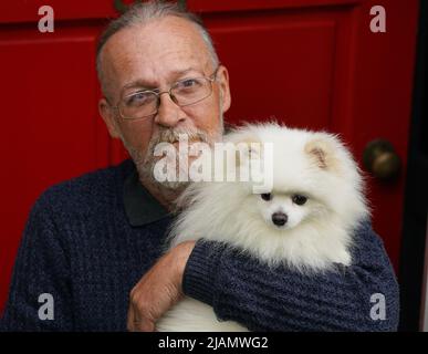 Mike Haley avec son Archie Pomeranien, âgé d'un an, qui a gardé les esprits de Mike et de sa femme Alla Haley lors de leur voyage de 2 000 miles de Kiev à Newcastle. La famille qui a fui la guerre en Ukraine a déclaré qu'elle était « très heureuse » de faire revenir son chien bien-aimé après avoir été mis en quarantaine par les autorités britanniques pendant plus de huit semaines. Date de la photo: Mardi 31 mai 2022. Banque D'Images