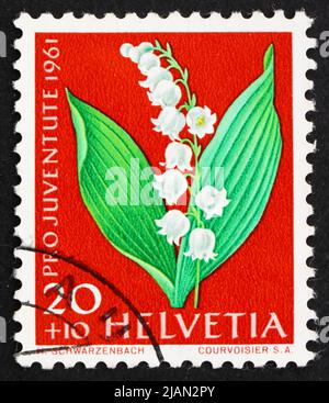 SUISSE - VERS 1961 : un timbre imprimé en Suisse montre le Lily de la vallée, Convallaria majalis, plante à fleurs, vers 1961 Banque D'Images