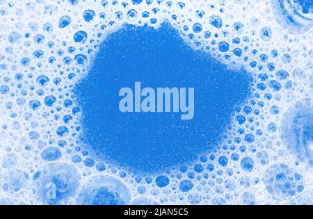 Gros plan sur la mousse de savon. Arrière-plan des bulles de shampooing savonneux de couleur bleue Banque D'Images