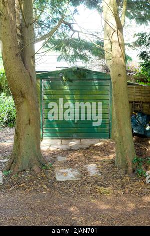 De grands arbres bloquent l'accès à un garage. Banque D'Images