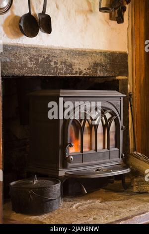 Poêle à bois en fonte noire sur cheminée foyer dans la cuisine à l'intérieur de la vieille maison en pierre de style cottage Canadiana vers 1840. Banque D'Images