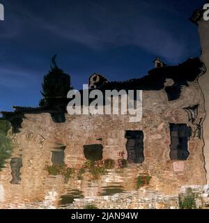 Vue carrée de bâtiments en pierre de couleur miel se reflétant dans l'eau chaude de source volcanique bouillant dans le 16th siècle bain de Sainte Catherine, une piscine rectangulaire dans le centre de Bagno Vignoni, Toscane, Italie. Les propriétés apaisantes et curatives de l'eau à vapeur ont été appréciées par les Etrusques, les Romains, Sainte Catherine de Sienne, le dirigeant des Médicis Lorenzo le magnifique, le Pape Pie II, l'écrivain Charles Dickens et le marquis de Sade. Banque D'Images