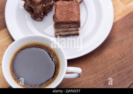 Goias, Brésil – 31 mai 2022 : une tasse de café avec des morceaux de paille italienne sur une surface en bois. Banque D'Images