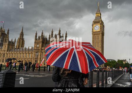 31 mai 2022. Un touriste porte un parapluie Union Jack lors d'une douche à effet pluie sur le pont de Westminster, Londres, Royaume-Uni Banque D'Images