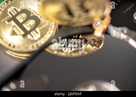 Bitcoin réfléchissant sur le disque dur. Pièce de monnaie crypto-or sur le matériel. Concept de crypto-monnaie minière Banque D'Images