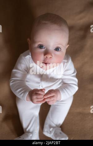 joyeux caucasien neuf mois bébé fille regardant la caméra pendant la maison photoshoot Banque D'Images