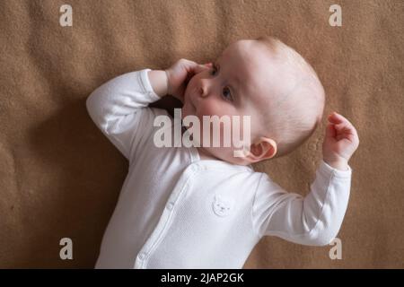 joyeux caucasien neuf mois bébé fille regardant la caméra pendant la maison photoshoot Banque D'Images