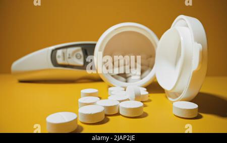 Thermomètre et un bouquet de pilules blanches. Banque D'Images