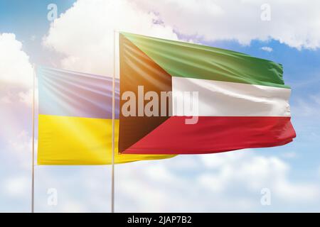 Ciel bleu ensoleillé et drapeaux du koweït et de l'ukraine Banque D'Images