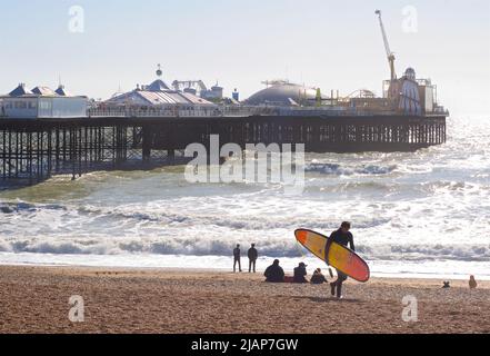 La plage de Brighton et la jetée du Palace lors d'une journée ensoleillée de mars. Surfez en surfant sur la plage. Brighton, Brighton & Hove, East Sussex, Angleterre, Royaume-Uni Banque D'Images