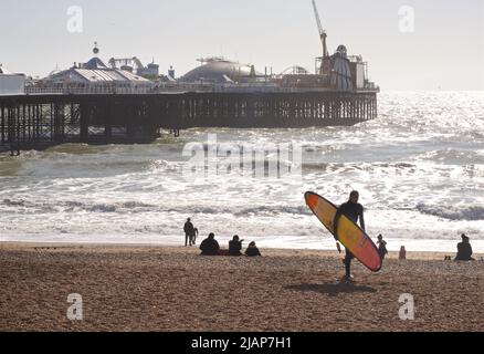 La plage de Brighton et la jetée du Palace lors d'une journée ensoleillée de mars. Surfez en surfant sur la plage. Brighton, Brighton & Hove, East Sussex, Angleterre, Royaume-Uni Banque D'Images