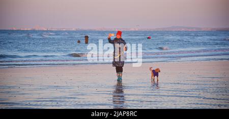 Promenade matinale avec un chien sur la plage de Brighton à marée basse. En regardant vers l'ouest avec Worthing au loin. Femme parlant selfie ou visiophonie avec le téléphone. Banque D'Images