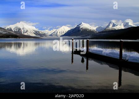 Un homme pêchant sur le lac McDonald en hiver. Le lac McDonald est le plus grand lac du parc national des Glaciers. Il est situé dans le comté de Flathead, dans le Montana, aux États-Unis d'Amérique. Le lac est d'environ 10 milles de long, et plus d'un mille de large et 472 pieds de profondeur, remplissant une vallée formée par une combinaison d'érosion et d'activité glaciaire. Une version unique et optimisée d'une image NPS, crédit : NPS/D.Restivo Banque D'Images