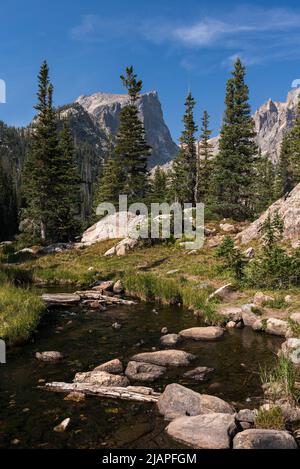 Un ruisseau coule de Dream Lake avec toile de fond de High Peaks le long de la ligne de partage continentale dans le Colorado. Banque D'Images