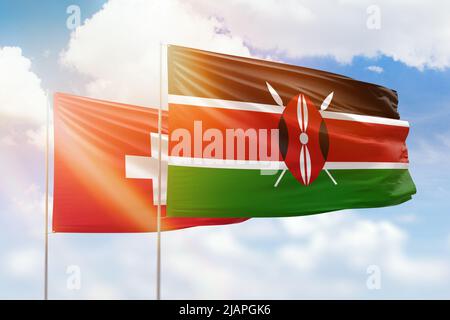 Ciel bleu ensoleillé et drapeaux du kenya et de la suisse Banque D'Images