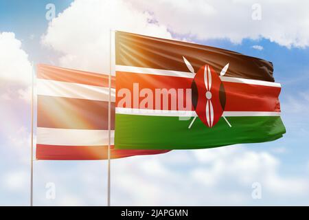 Ciel bleu ensoleillé et drapeaux du kenya et de la thaïlande Banque D'Images