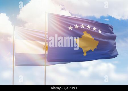 Ciel bleu ensoleillé et drapeaux du kosovo et de l'argentine Banque D'Images