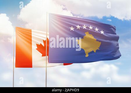 Ciel bleu ensoleillé et drapeaux du kosovo et du canada Banque D'Images