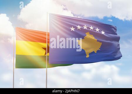 Ciel bleu ensoleillé et drapeaux du kosovo et du ghana Banque D'Images