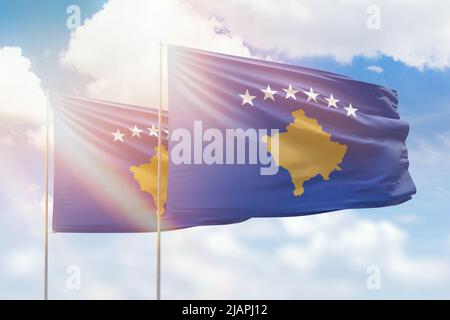 Ciel bleu ensoleillé et drapeaux du kosovo et du kosovo Banque D'Images