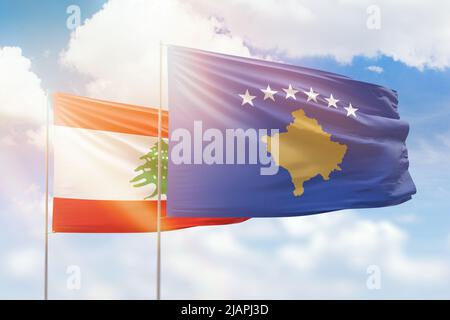 Ciel bleu ensoleillé et drapeaux du kosovo et du liban Banque D'Images