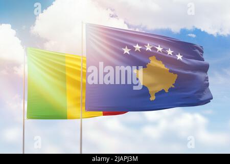 Ciel bleu ensoleillé et drapeaux du kosovo et du mali Banque D'Images
