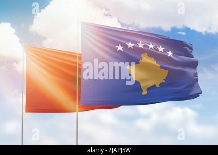 Ciel bleu ensoleillé et drapeaux du kosovo et du maroc Banque D'Images