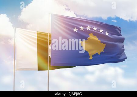 Ciel bleu ensoleillé et drapeaux du kosovo et du pakistan Banque D'Images